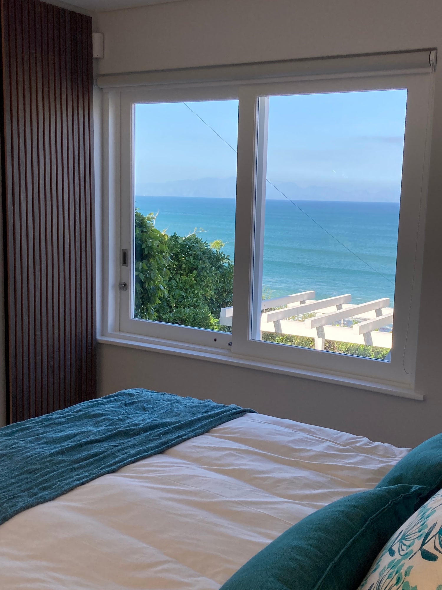 Akupanels behind a bed with a seaview